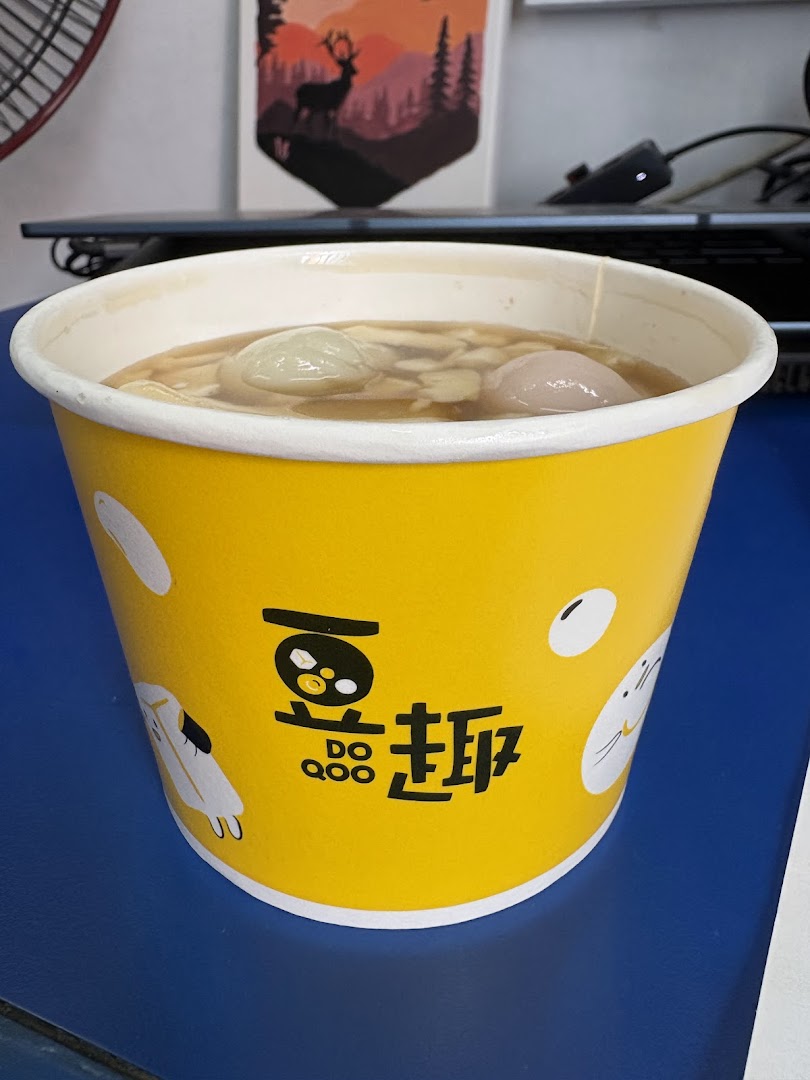 A close-up of a delicious dessert from Do Qoo 豆趣 in a yellow branded cup.