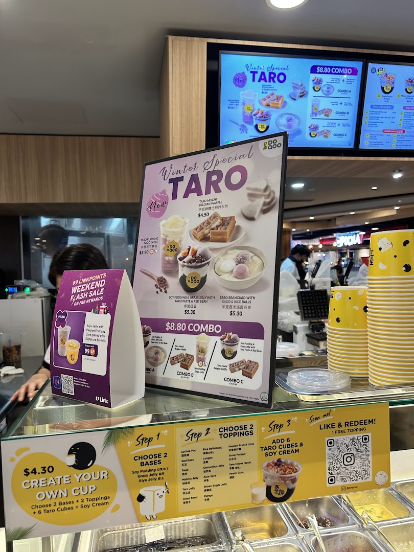 A shop counter displaying various taro-themed desserts and drinks with prominent menu boards.