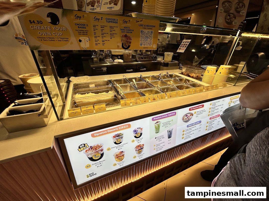 A vibrant counter at Do Qoo 豆趣 showcasing fresh ingredients and digital menu displays.