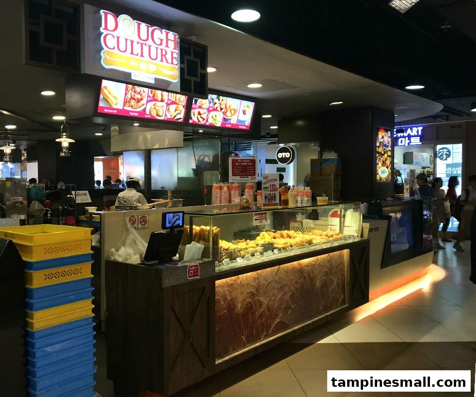 Dough Culture's counter displaying freshly baked dough products and digital menu boards.