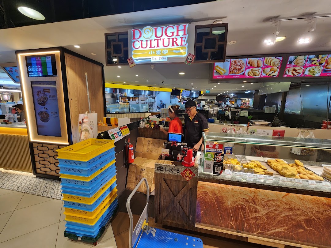 Staff serve customers at Dough Culture, showcasing a display of freshly fried dough products.