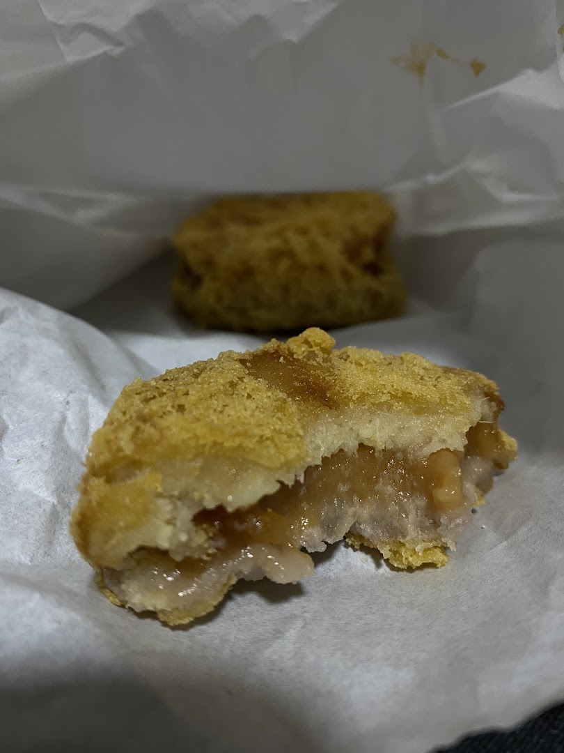 Close-up of a golden-fried pastry, cut open to reveal a soft, sweet yam filling.