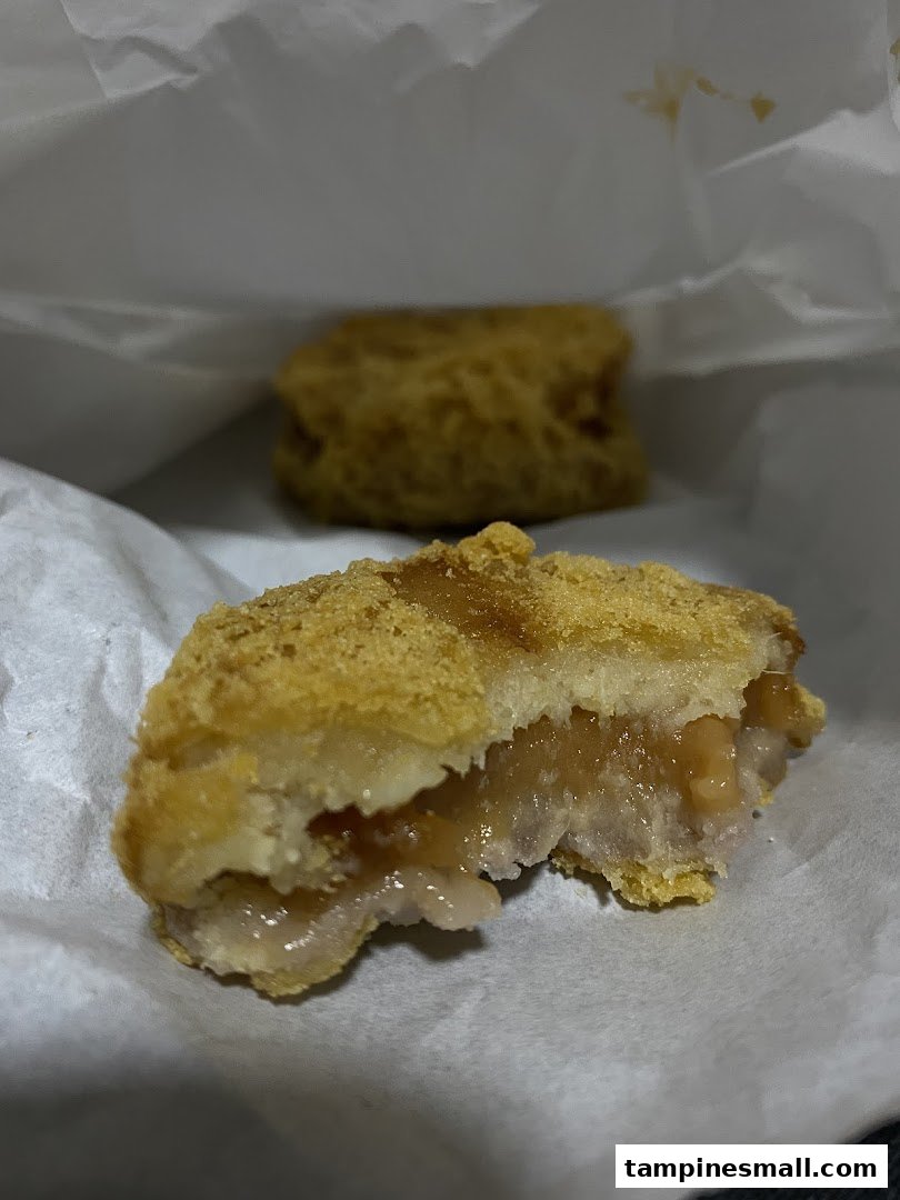 Close-up of a golden-fried pastry, cut open to reveal a soft, sweet yam filling.