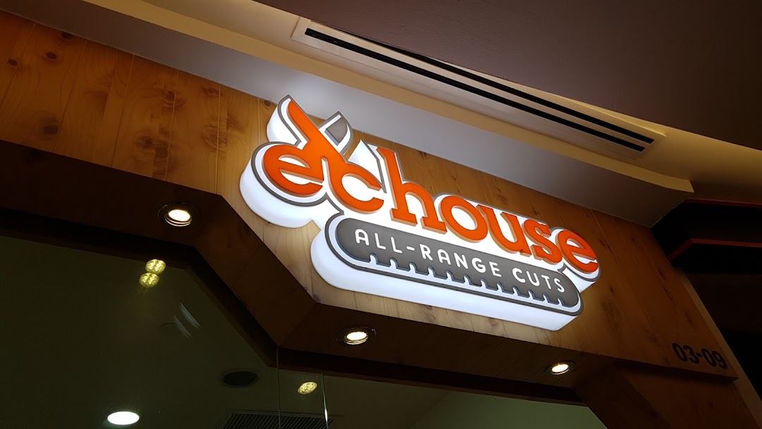 Close-up of the illuminated EC House All-Range Cuts shop sign at Tampines Mall.