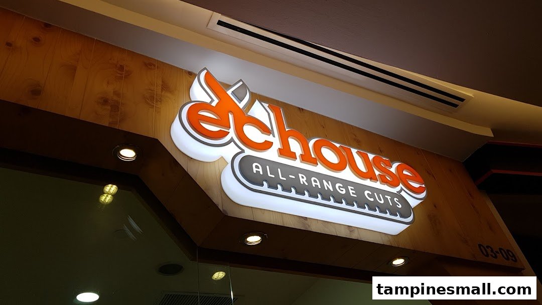 Close-up of the illuminated EC House All-Range Cuts shop sign at Tampines Mall.
