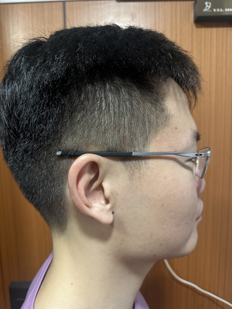 Side profile of a person showcasing a fresh, modern haircut with faded sides.