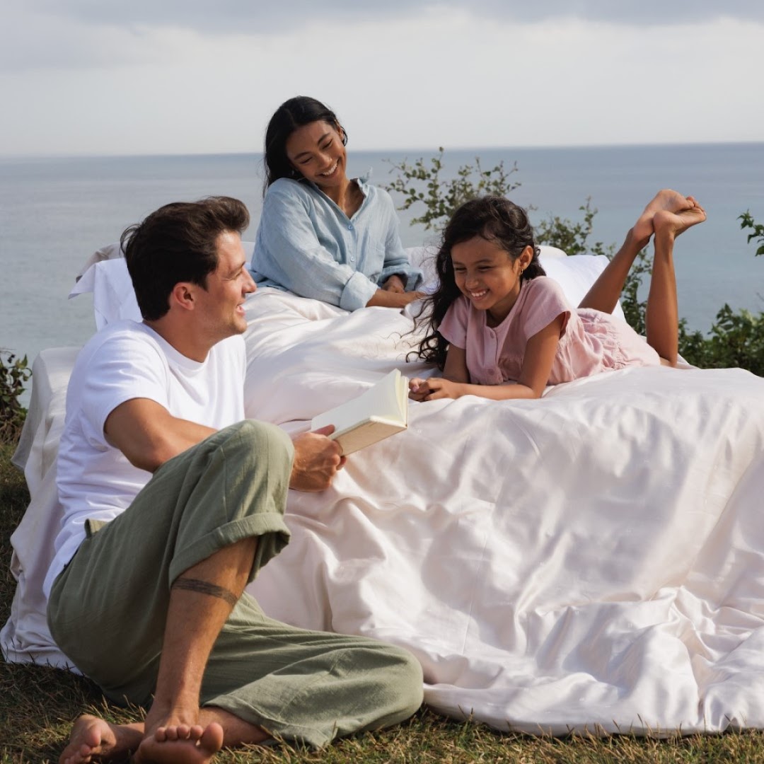 A family enjoys comfortable bedding outdoors by the sea, showcasing Epitex's quality and comfort.