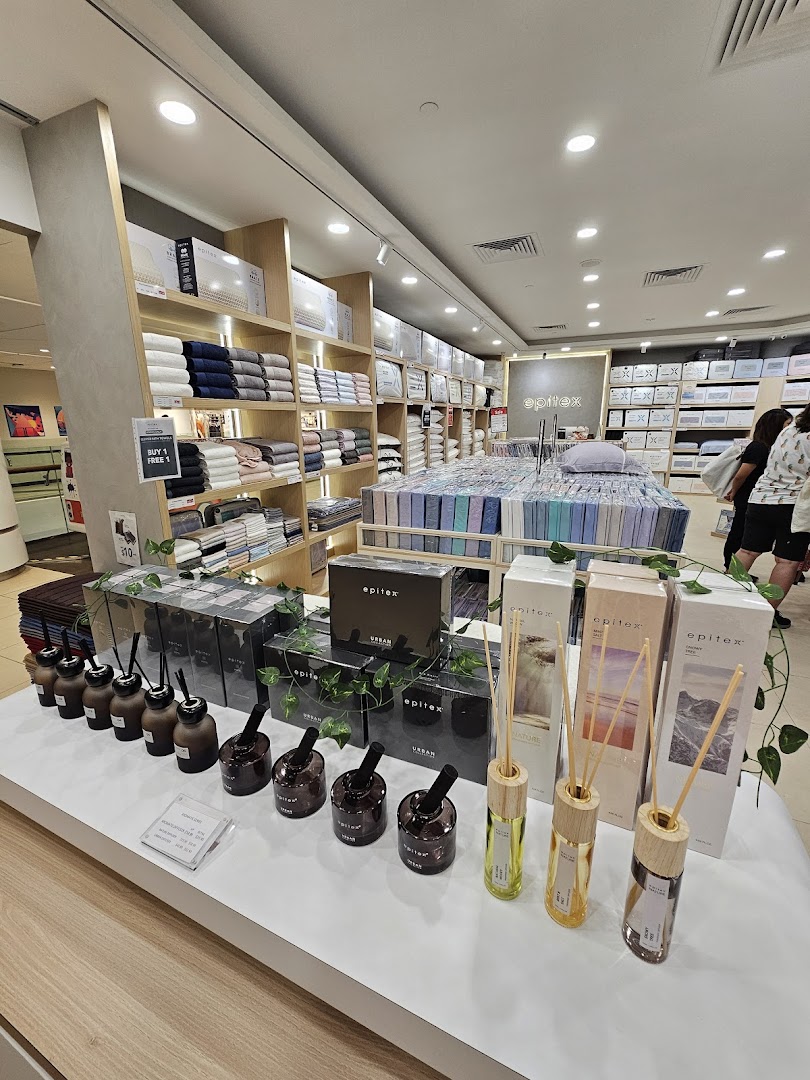 Interior view of Epitex showcasing bedding, towels, and home fragrance diffusers on display.