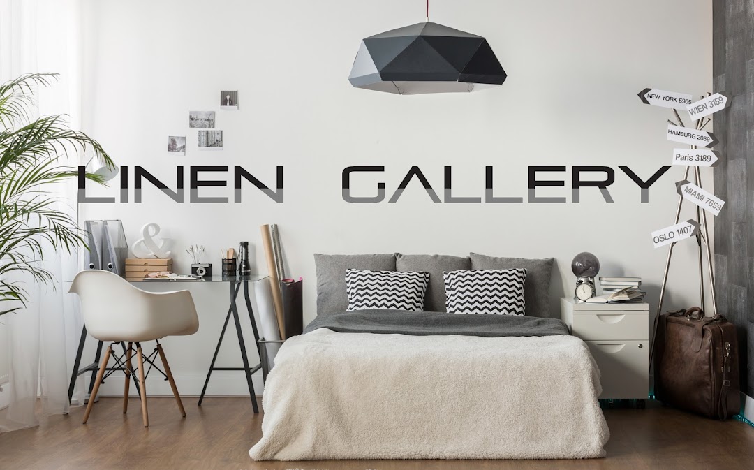 A stylish bedroom display featuring a bed with cozy linens, a modern desk, and decorative elements.