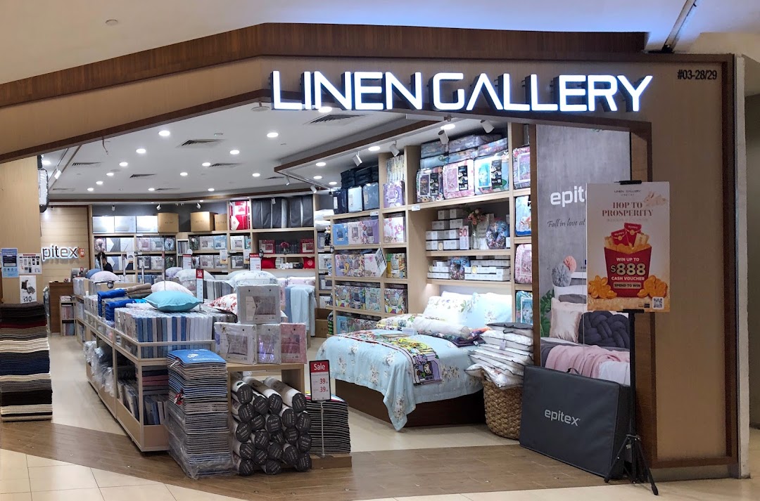 The Epitex Linen Gallery shop front displays a wide range of bedding, pillows, and home textiles, including a styled bed.
