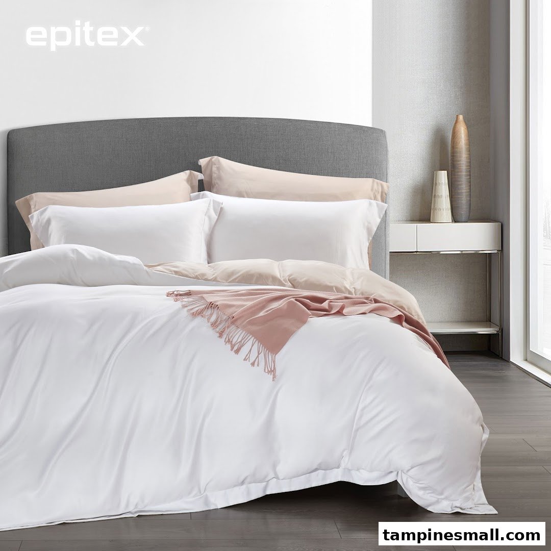 A beautifully made bed featuring white and beige bedding with a pink throw blanket.