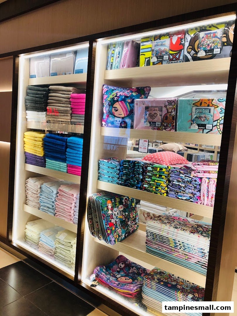 Shelves displaying a vibrant collection of Epitex home textiles, including towels and character-themed bedding.