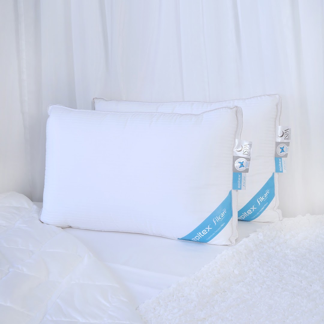 Two white Epitex Filcare pillows displayed on a bed with white bedding.