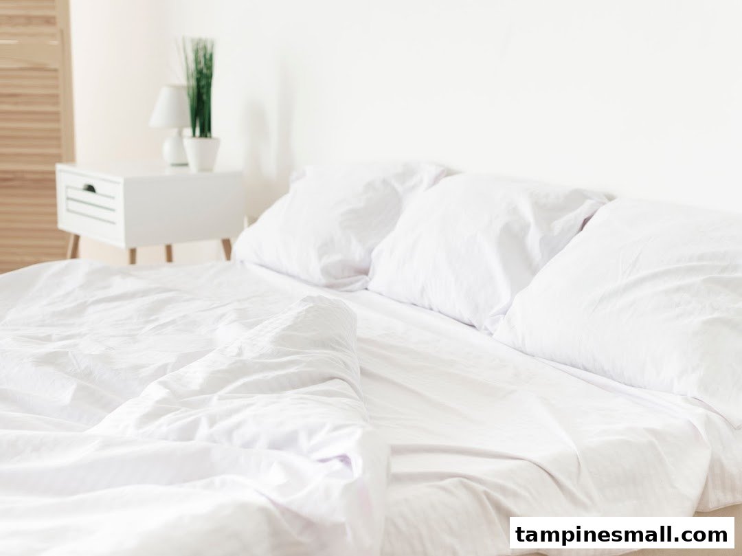A clean, bright bedroom scene featuring a bed with crisp white bedding and pillows.