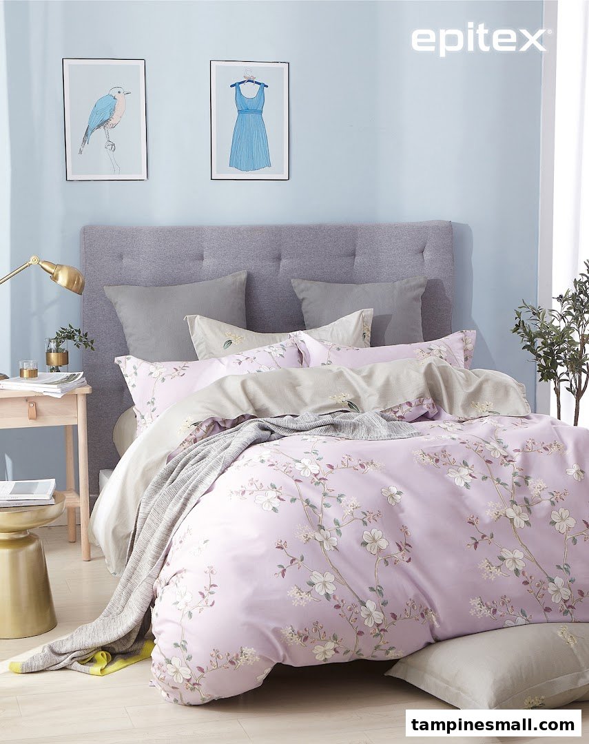 A beautifully styled bed featuring lavender floral bedding, grey pillows, and a tufted headboard.