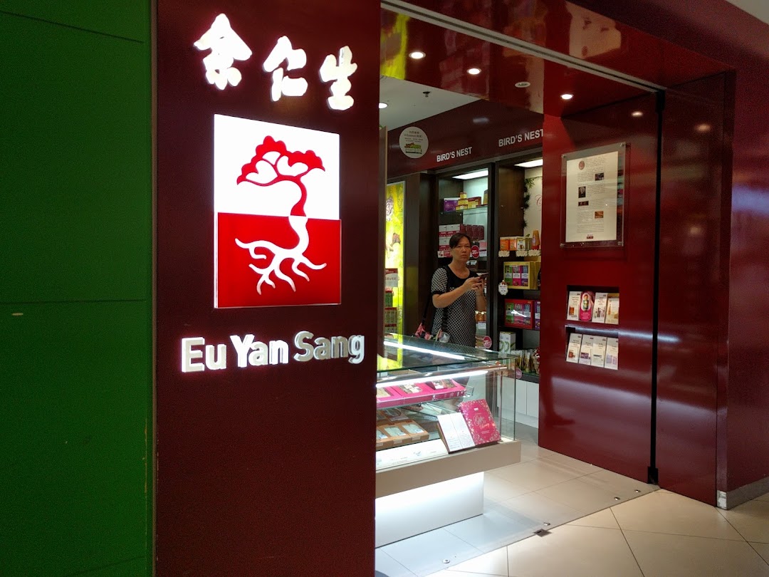 The entrance of Eu Yan Sang, a traditional Chinese medicine shop, with a staff member visible inside.