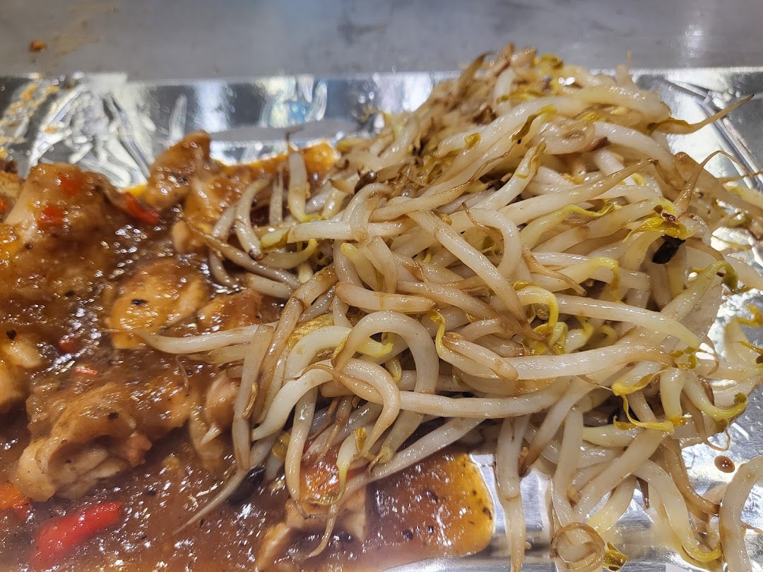 A close-up of savory teppanyaki chicken with vibrant stir-fried bean sprouts.
