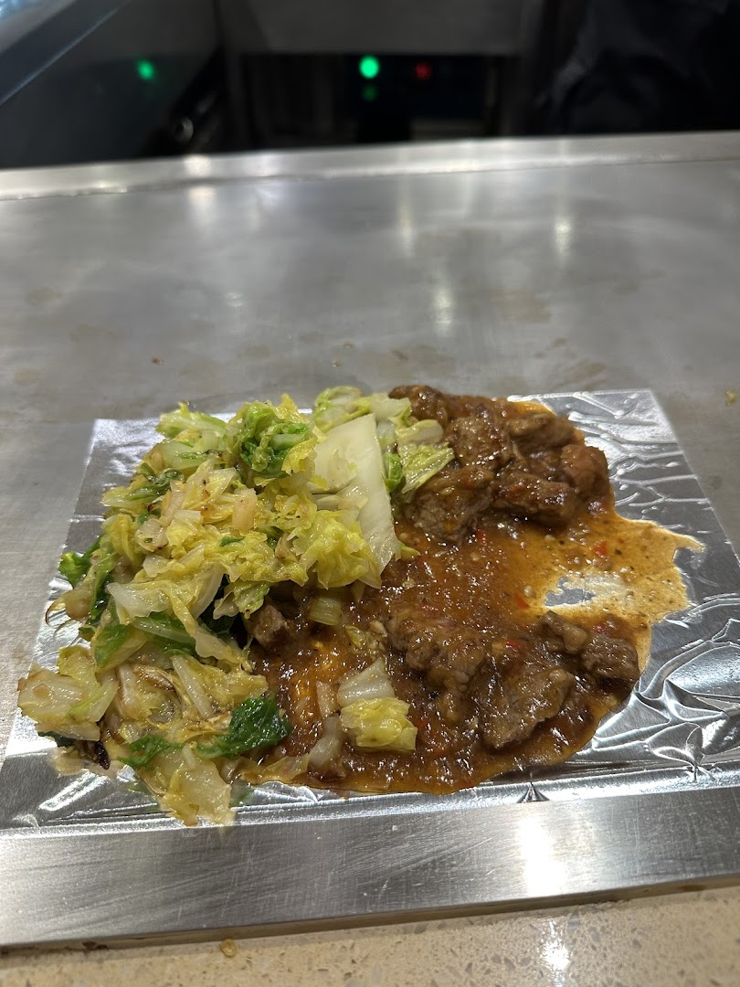 Delicious teppan-yaki beef and cabbage sizzling on a hot plate, ready to be enjoyed.