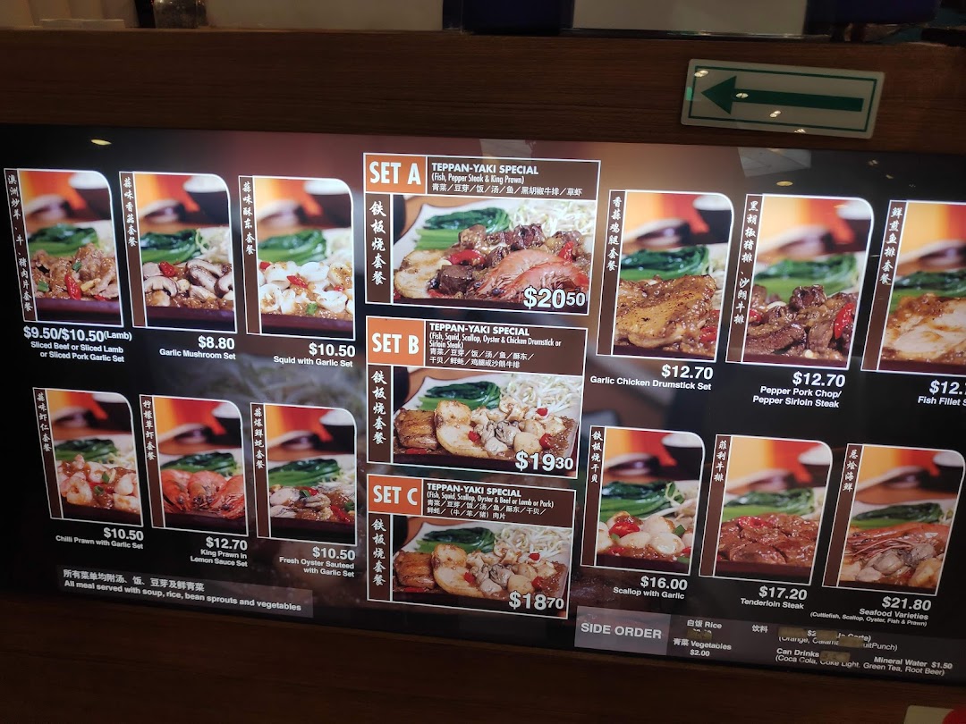 A digital menu board displaying various teppanyaki sets and individual dishes with prices and images.