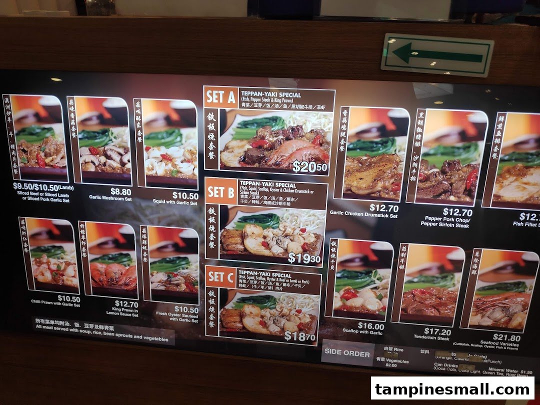 A digital menu board displaying various teppanyaki sets and individual dishes with prices and images.