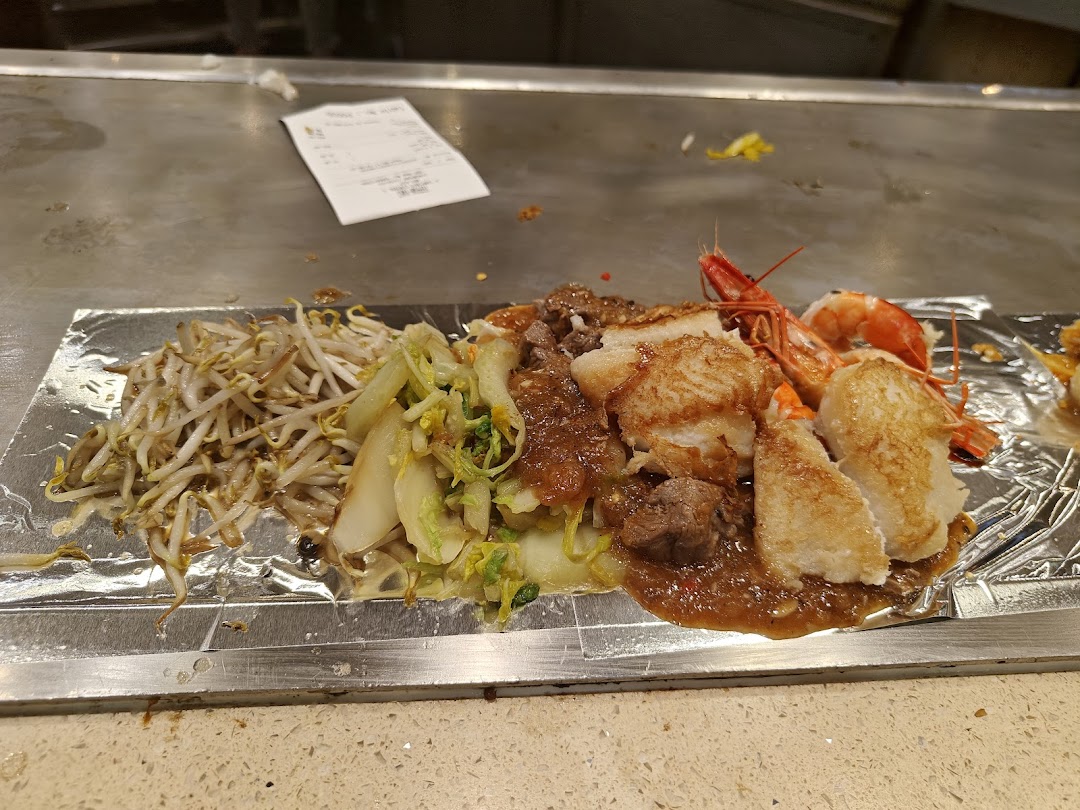 A delicious teppan-yaki meal with seafood, meat, and vegetables served on a hot grill.