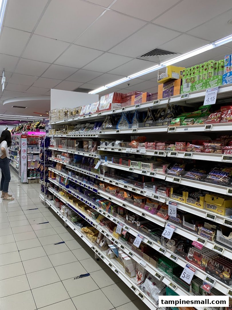 An aisle in FairPrice Tampines Mall featuring a wide selection of chocolates and snacks.