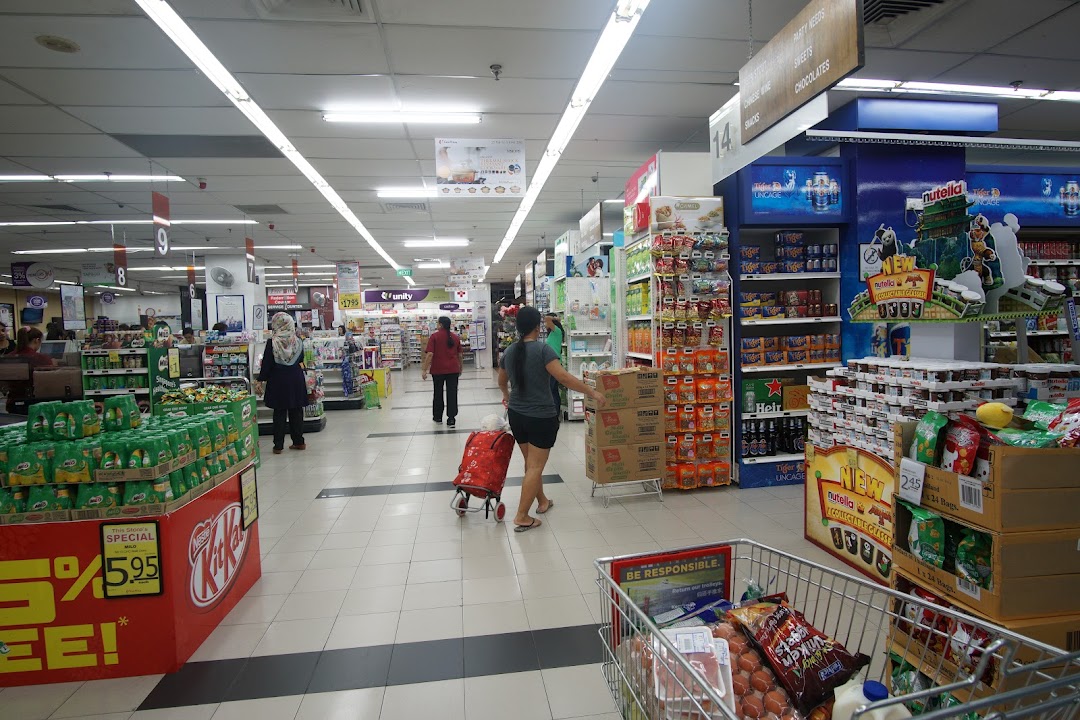 A bustling supermarket aisle at FairPrice Tampines Mall, showcasing diverse products and shoppers.