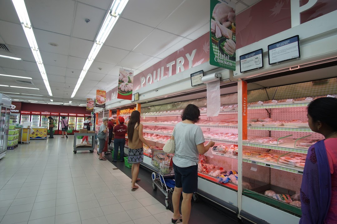Shoppers browse fresh poultry and meat selections in a well-stocked supermarket aisle.