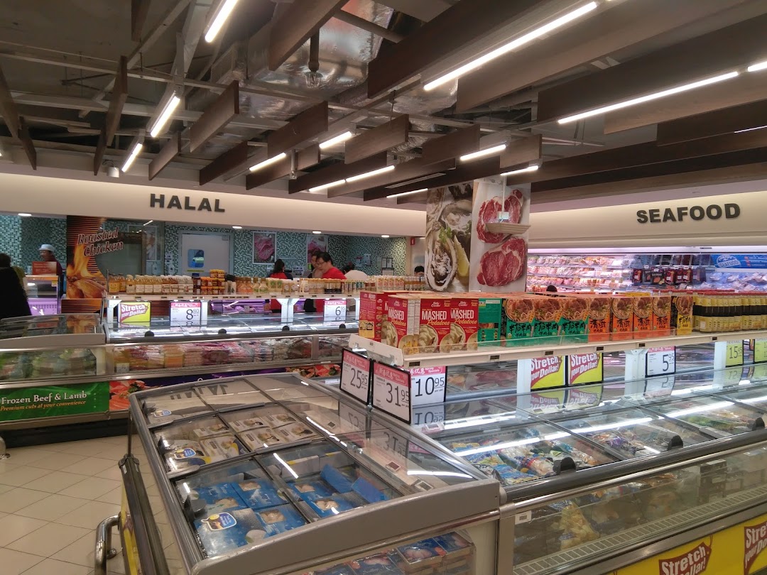 Interior view of FairPrice supermarket showcasing fresh food sections like Halal and Seafood, with refrigerated displays.