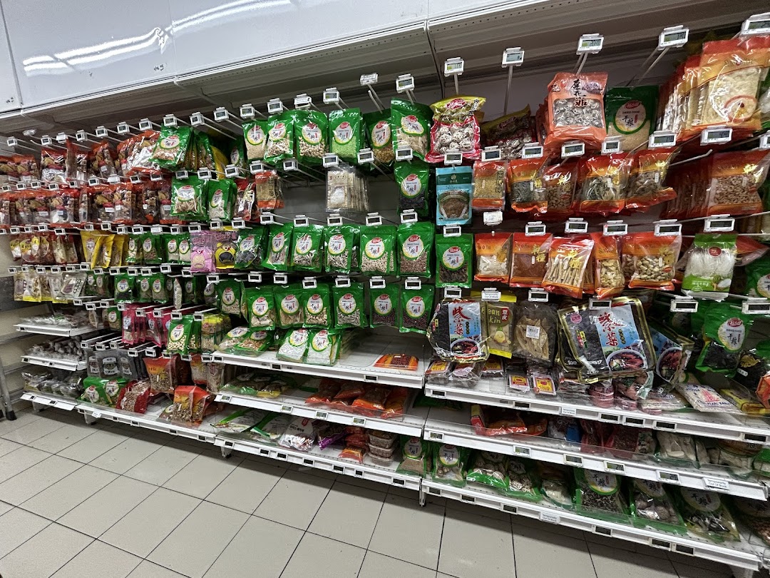 A well-stocked supermarket aisle displaying a wide variety of packaged dried goods, nuts, and spices.