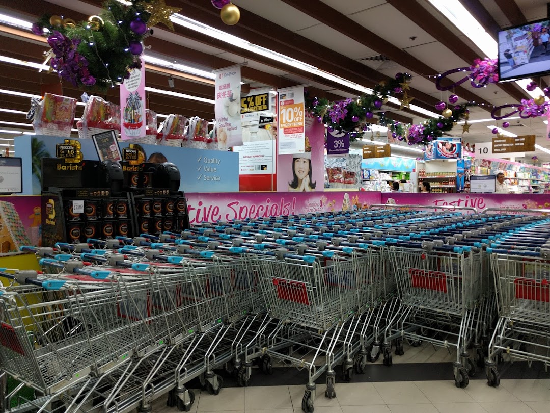 Interior view of FairPrice supermarket featuring rows of shopping carts, product displays, and festive decorations.