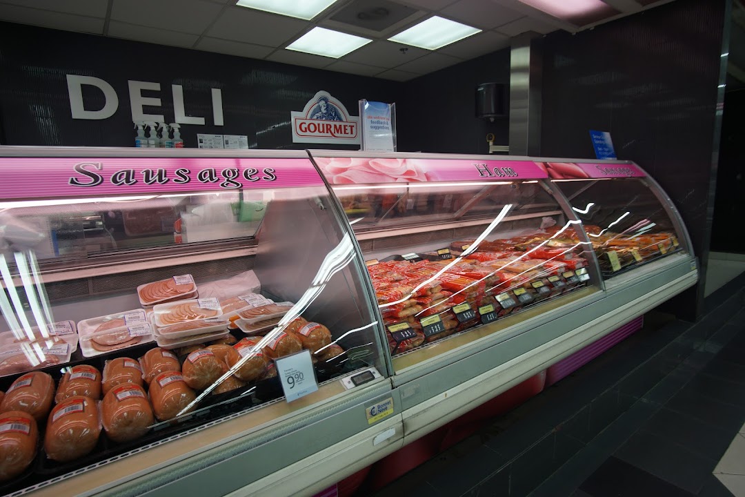 A well-stocked deli counter at FairPrice Tampines Mall, featuring a variety of sausages and ham.