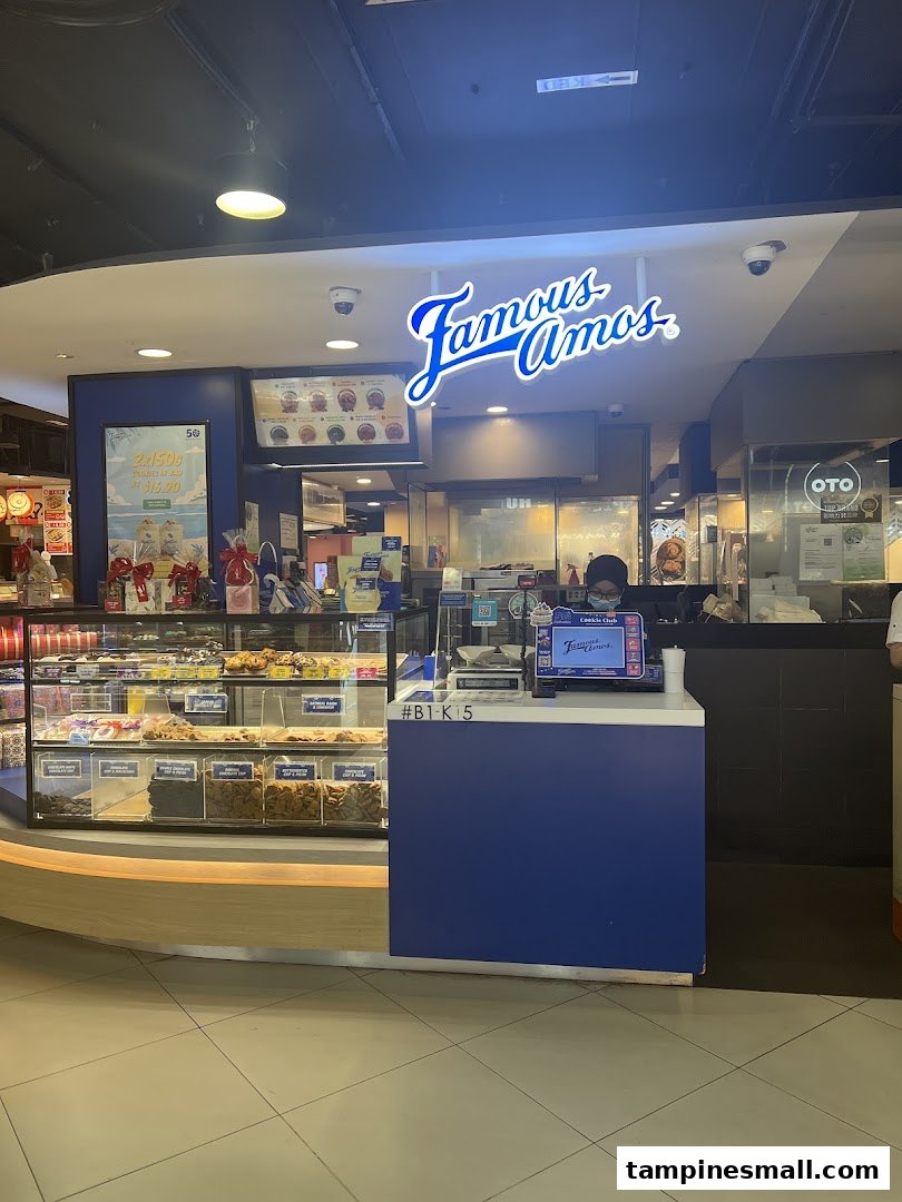 Famous Amos cookie shop front with display cases full of freshly baked cookies and a counter.
