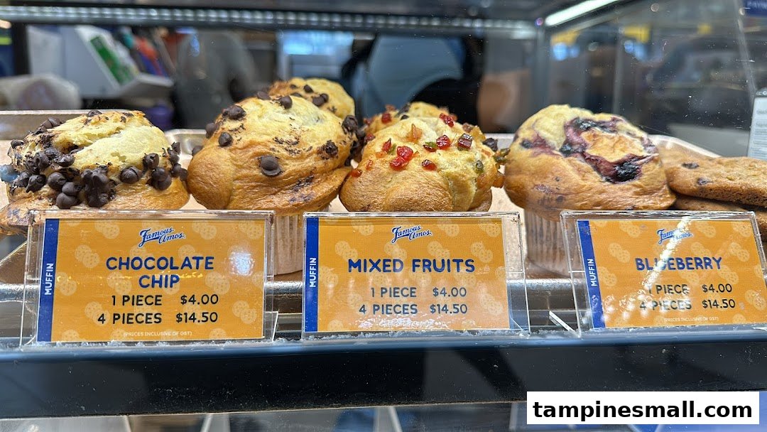 A display case showcasing various Famous Amos muffins with their prices.