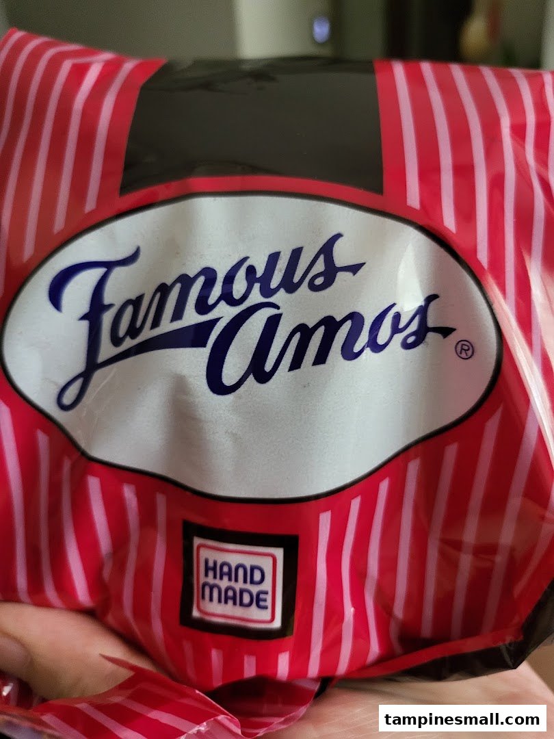Close-up of a Famous Amos cookie bag featuring the brand logo and 'Hand Made' label.