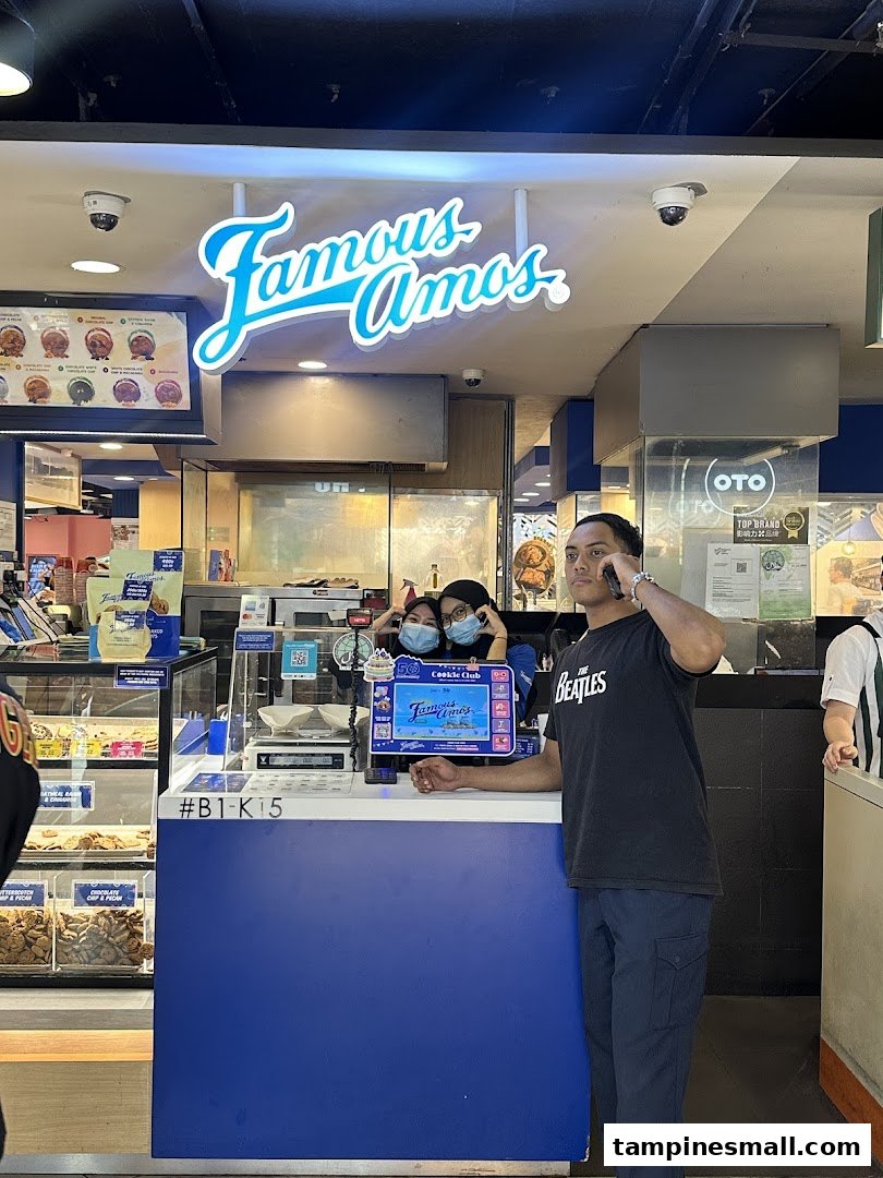 An interior view of Famous Amos, showcasing the counter, cookie displays, and staff.