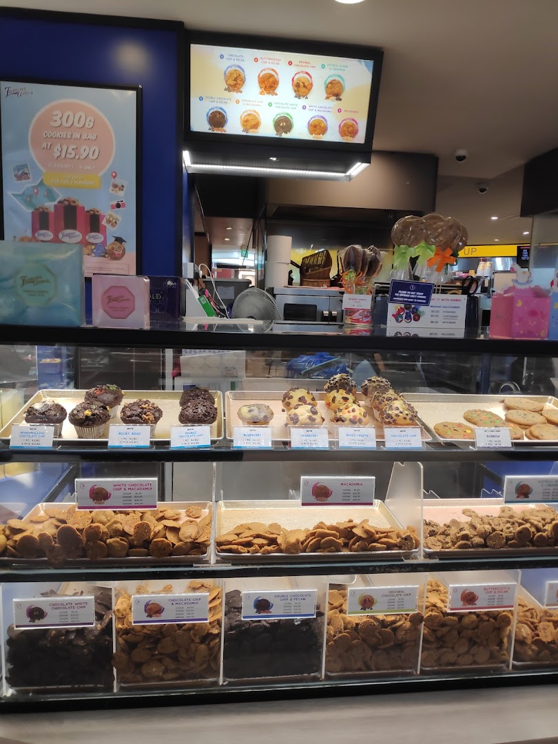 A vibrant display counter at Famous Amos showcasing a variety of freshly baked cookies and treats.