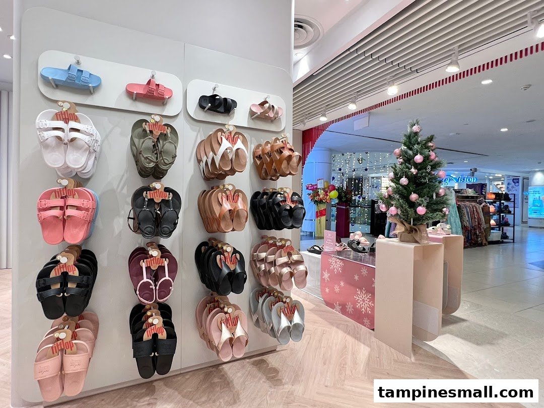 A vibrant display of FitFlop sandals in various colors, showcased in a mall setting with a festive Christmas tree.
