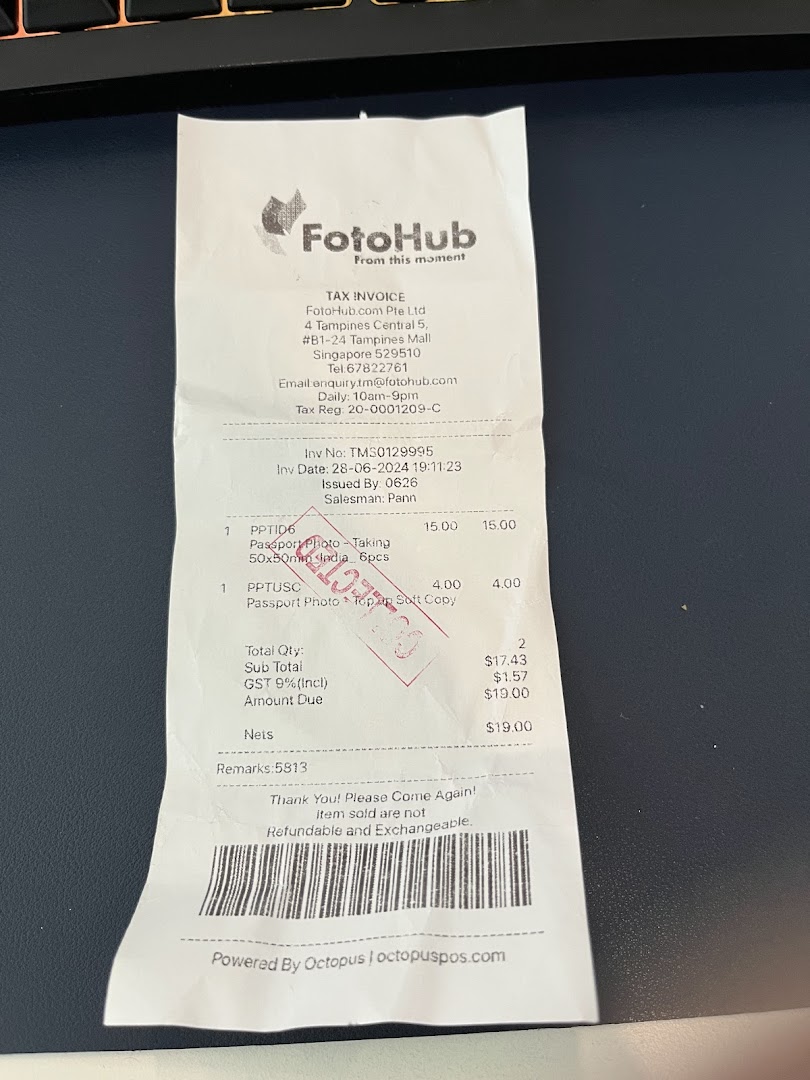 A FotoHub tax invoice detailing passport photo services and charges.