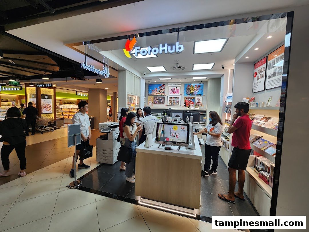 Customers interact with staff and kiosks at FotoHub, a photo printing and imaging service shop.