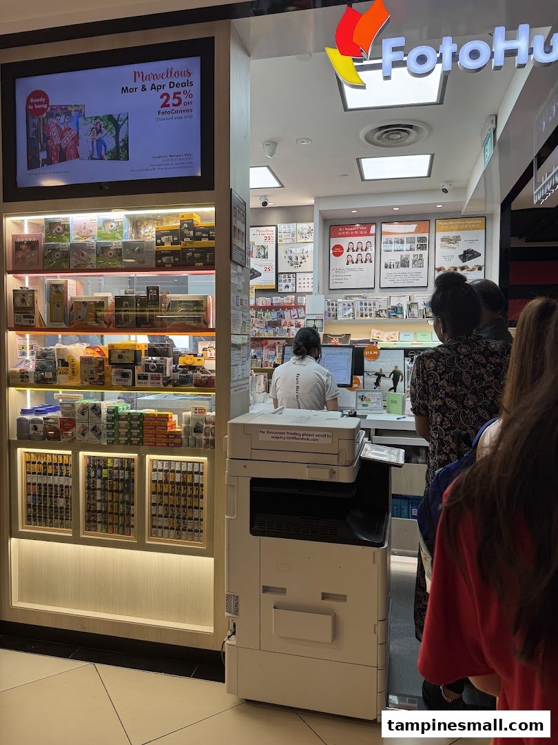 FotoHub shop front with digital displays, product shelves, and customers at the counter.