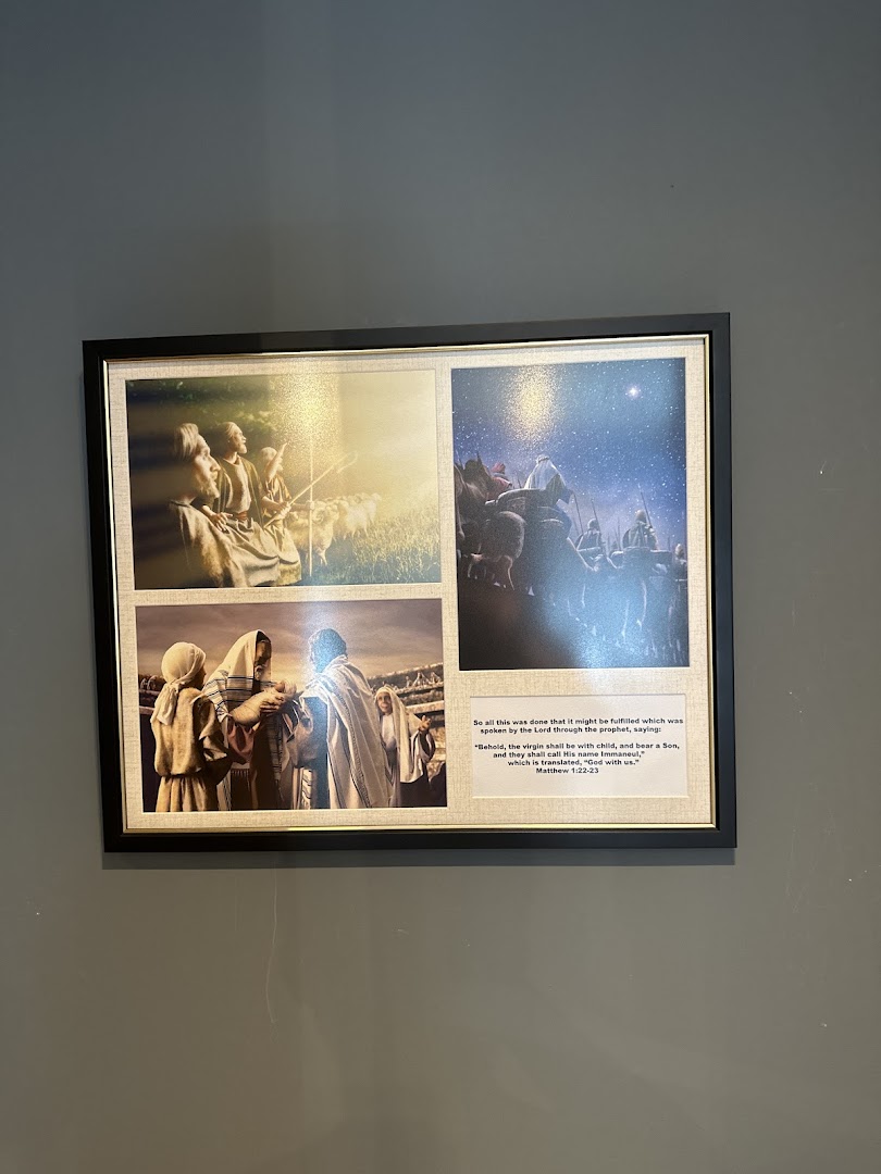 A framed picture on a wall, featuring religious scenes and a Bible verse.