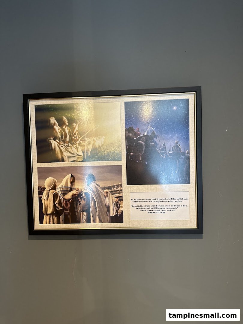 A framed picture on a wall, featuring religious scenes and a Bible verse.