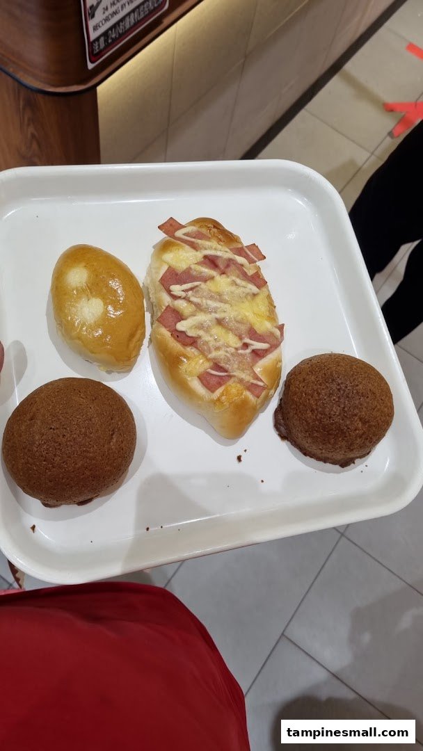 A white tray holds four freshly baked pastries, including sweet and savory options.