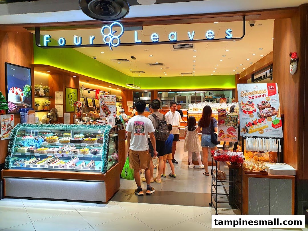 The brightly lit entrance of Four Leaves bakery, showcasing a display case filled with cakes and pastries.