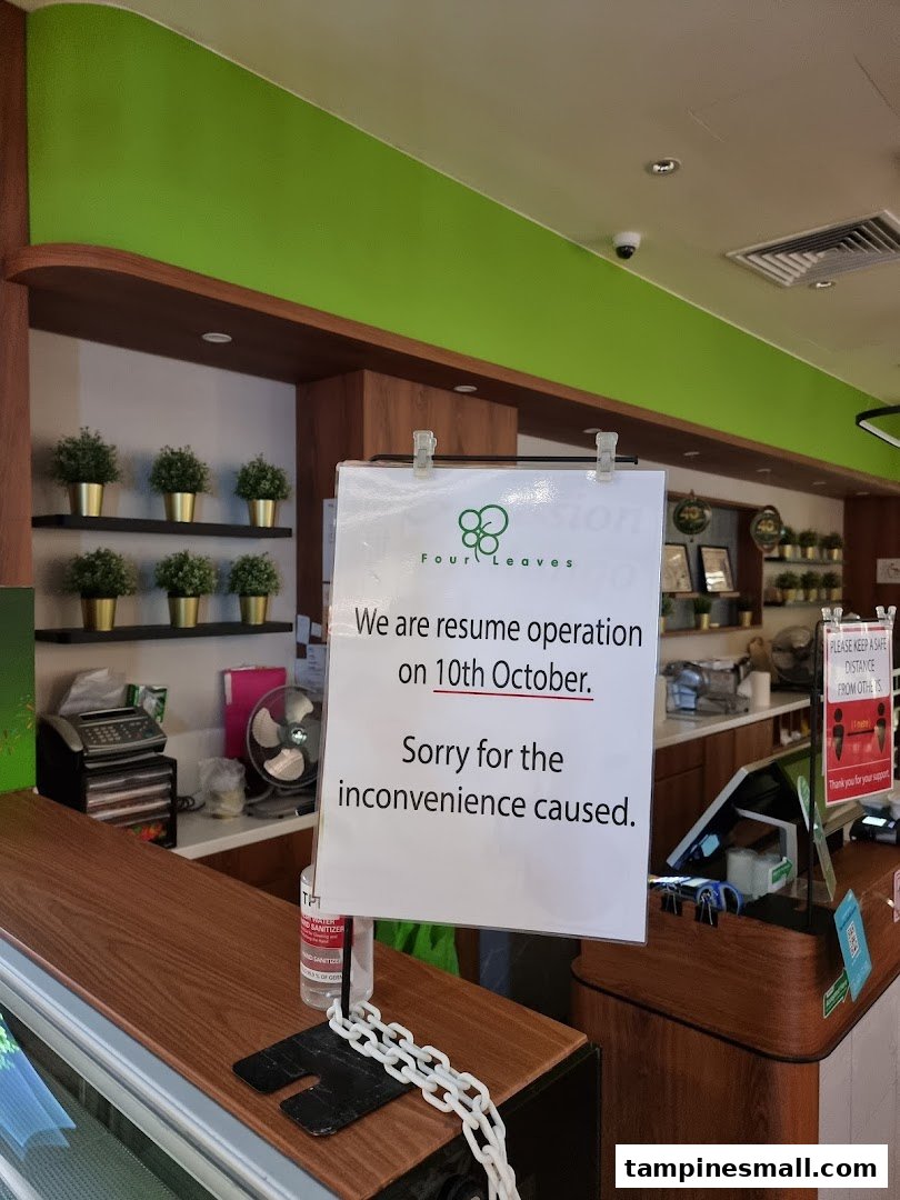 An interior view of Four Leaves, featuring a counter and a sign announcing operations resume on October 10th.