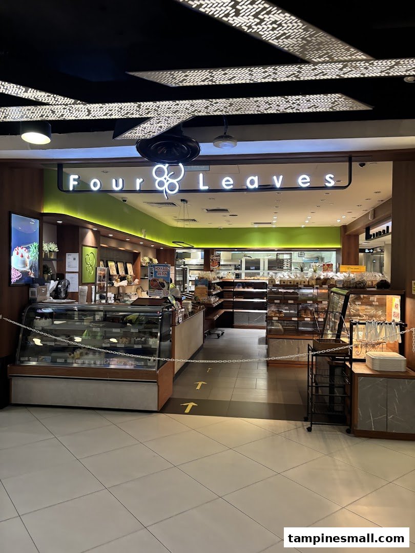 The entrance of Four Leaves bakery, showcasing display cases filled with cakes and freshly baked goods.