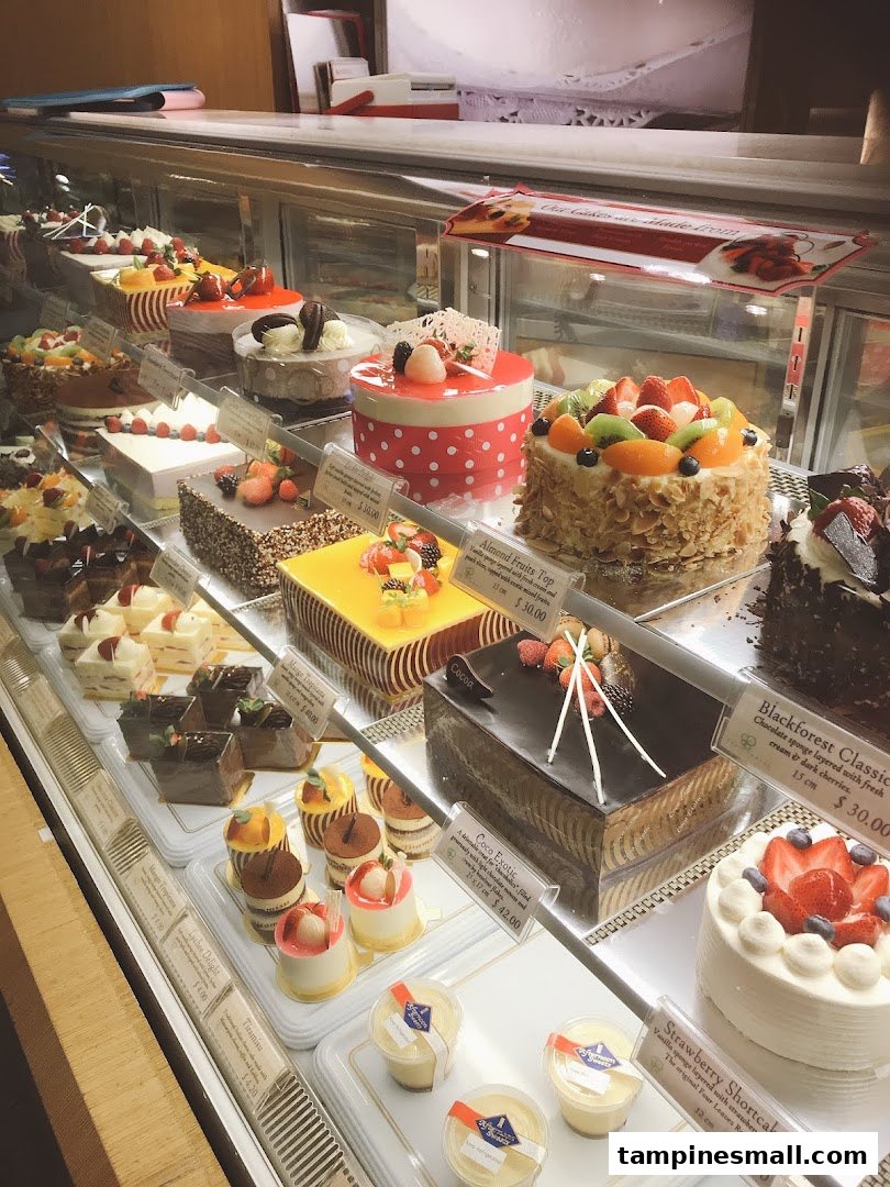 A vibrant display case showcasing a variety of beautifully decorated cakes and pastries.