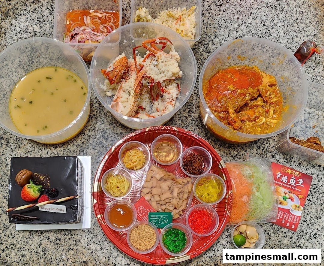 A diverse spread of gourmet takeaway dishes, including seafood, soup, a birthday cake, and a Yu Sheng platter, ready for a celebration.