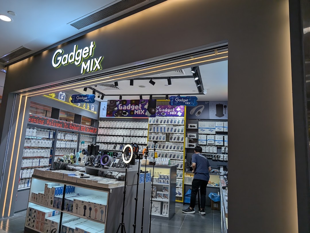 The brightly lit entrance of Gadget Mix, a tech accessories store, with products and a customer visible inside.